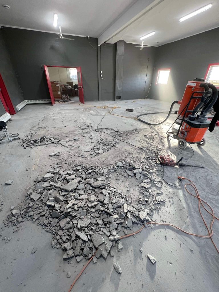 Close-up of a Warehouse floor with broken, cracked concrete before being repaired and finished with epoxy coating