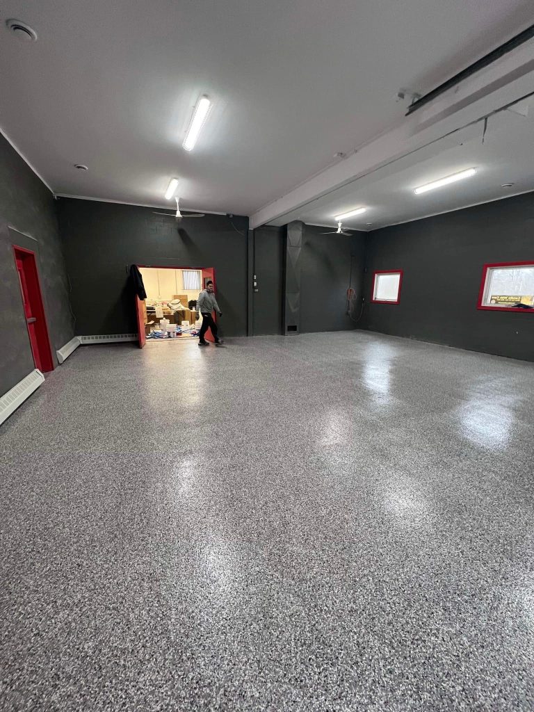 Smooth and polished epoxy floor finished with Geneva flake, featuring a light gray and white speckled design for a clean, modern look